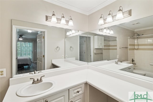 bathroom featuring ceiling fan, vanity, ornamental molding, and tiled shower / bath combo