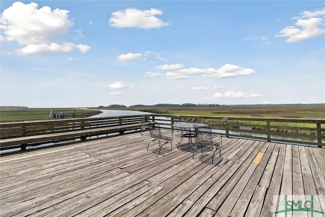 wooden deck with a rural view and a water view