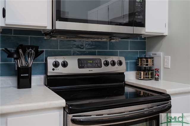 kitchen featuring backsplash, white cabinets, and stainless steel appliances