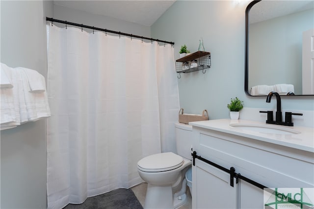 bathroom with vanity, a textured ceiling, and toilet