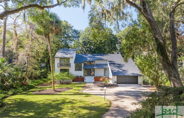 view of front facade featuring a balcony, a front yard, and a garage