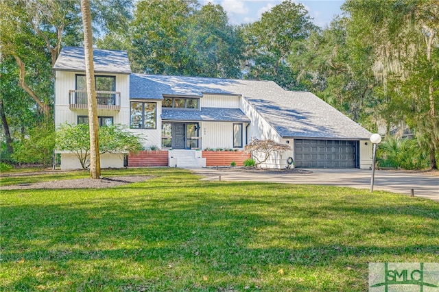 view of front of property featuring a front yard, a balcony, and a garage