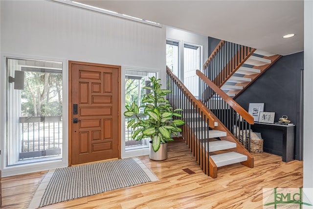 foyer entrance with a wealth of natural light and hardwood / wood-style flooring