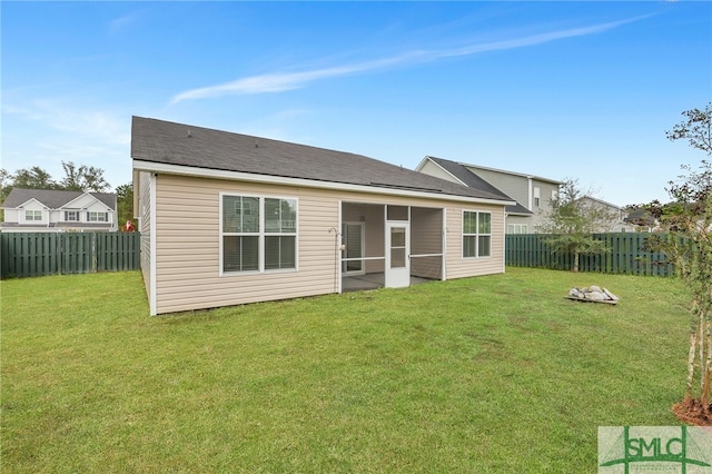 back of house featuring a lawn and a sunroom