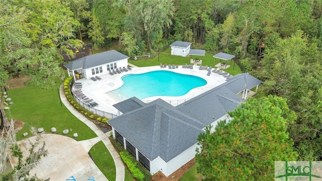 view of swimming pool featuring a lawn, a patio area, and an outdoor structure