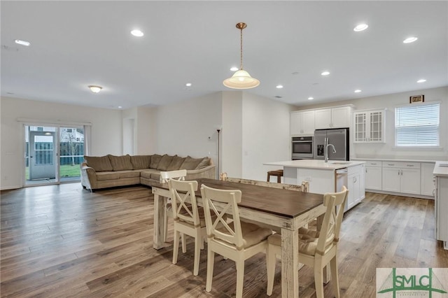 dining room with sink and light hardwood / wood-style flooring