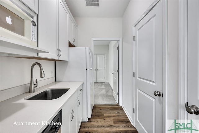 kitchen featuring dark hardwood / wood-style flooring, white cabinetry, sink, and white appliances