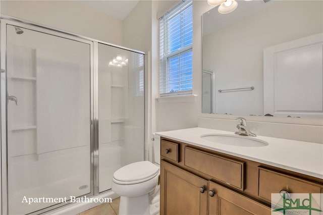 bathroom with tile patterned flooring, vanity, toilet, and walk in shower