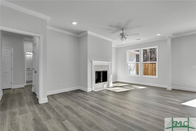 unfurnished living room featuring ceiling fan, ornamental molding, a premium fireplace, and hardwood / wood-style floors