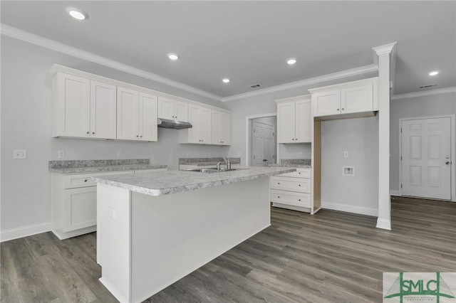 kitchen with white cabinetry, crown molding, dark hardwood / wood-style floors, and an island with sink