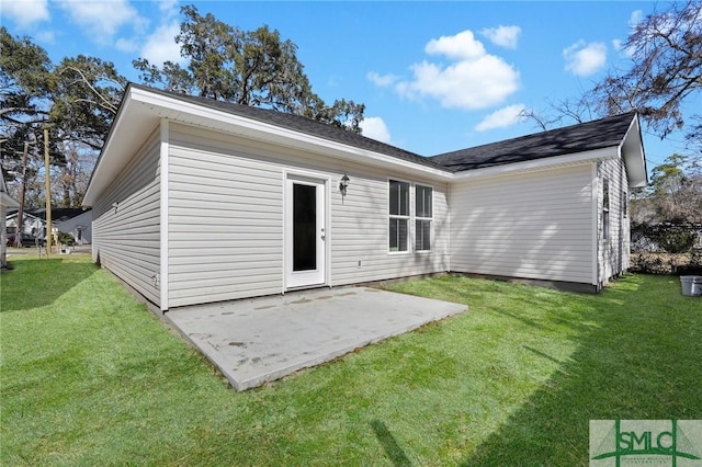 rear view of property featuring a yard and a patio