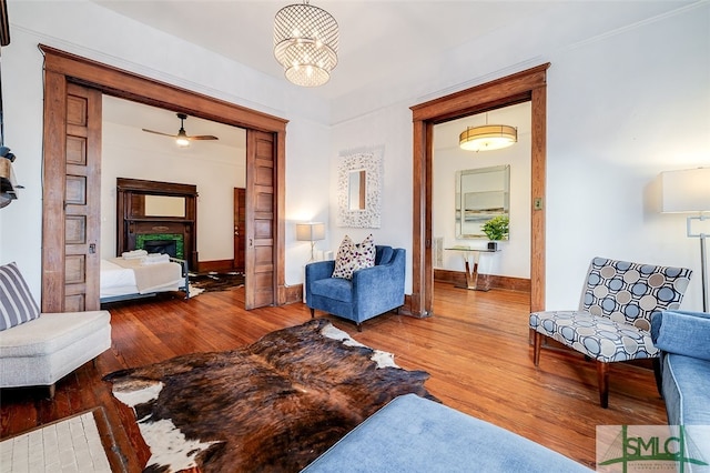 living room with wood-type flooring and ceiling fan with notable chandelier