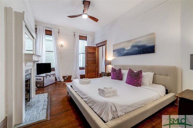 bedroom with dark hardwood / wood-style floors, multiple windows, and ceiling fan