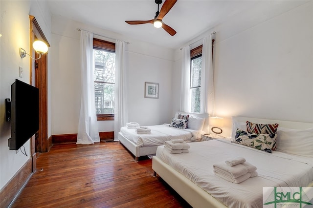 bedroom with ceiling fan and dark wood-type flooring