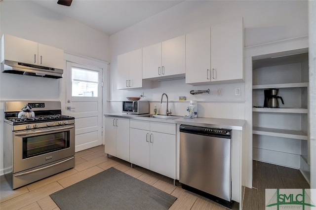 kitchen with stainless steel appliances, white cabinetry, light hardwood / wood-style floors, and sink