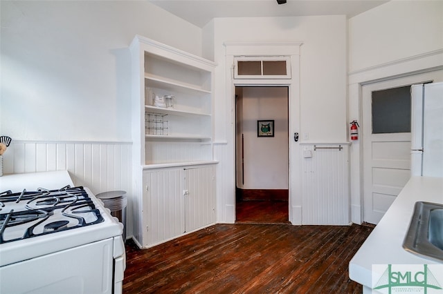 kitchen with white cabinetry, dark hardwood / wood-style flooring, white appliances, and sink