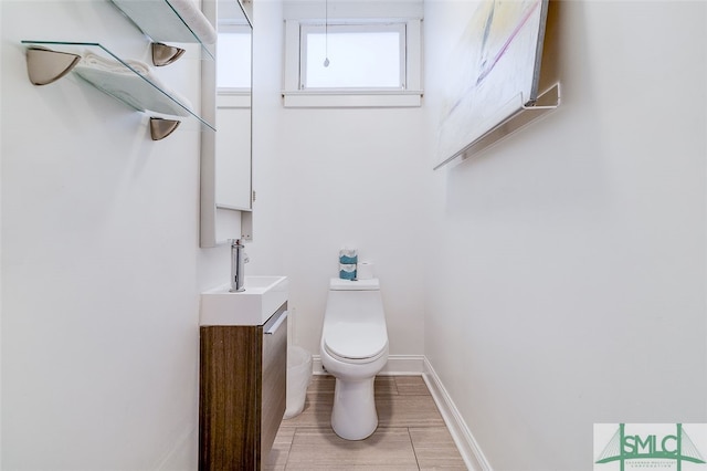 bathroom with wood-type flooring, vanity, and toilet