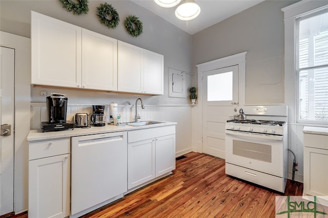 kitchen with white cabinets, white appliances, and sink