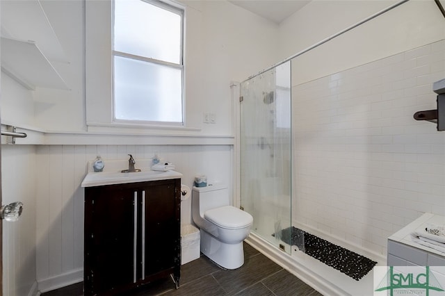 bathroom featuring vanity, toilet, and a shower with shower door