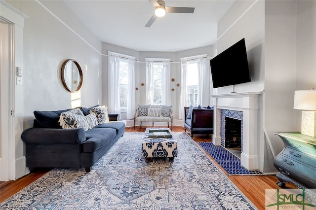 living room featuring a fireplace, hardwood / wood-style floors, and ceiling fan