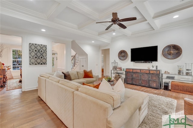 living room featuring coffered ceiling, crown molding, light hardwood / wood-style flooring, ceiling fan, and beamed ceiling