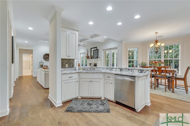 kitchen featuring stainless steel dishwasher, white cabinetry, and light hardwood / wood-style flooring