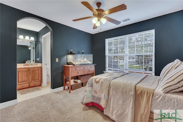 carpeted bedroom featuring ceiling fan and ensuite bathroom