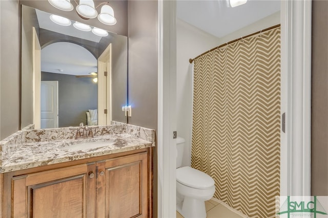 bathroom featuring vanity, tile patterned flooring, ceiling fan, toilet, and walk in shower