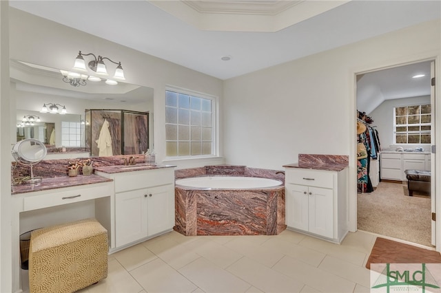 bathroom featuring a washtub, vanity, tile patterned floors, and crown molding