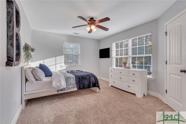 carpeted bedroom featuring ceiling fan and multiple windows