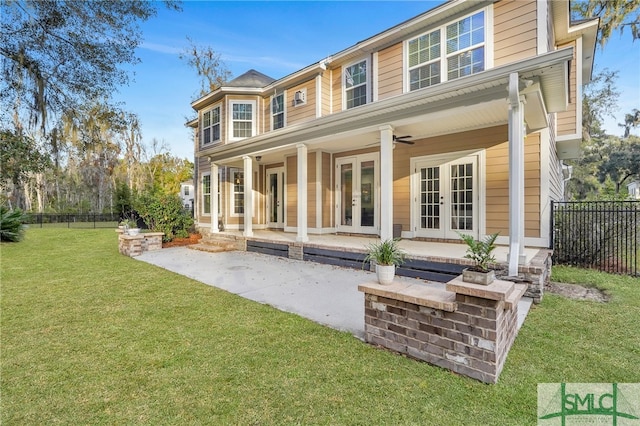 back of house with french doors and a lawn