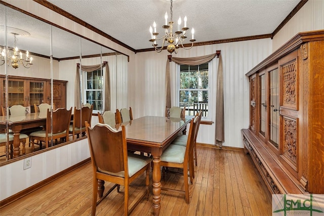 dining space with crown molding, light wood-type flooring, a textured ceiling, and a notable chandelier