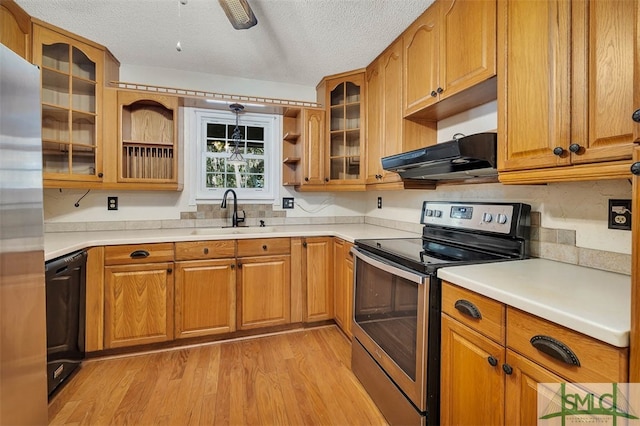 kitchen featuring exhaust hood, sink, light hardwood / wood-style flooring, a textured ceiling, and stainless steel appliances