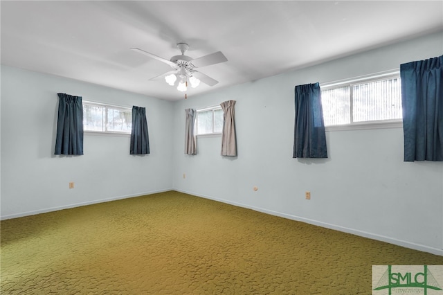 carpeted spare room featuring ceiling fan