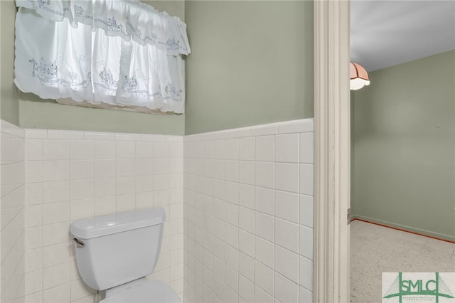 bathroom with toilet and tile walls