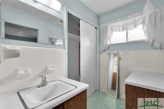 bathroom with decorative backsplash, tile patterned flooring, vanity, and tile walls