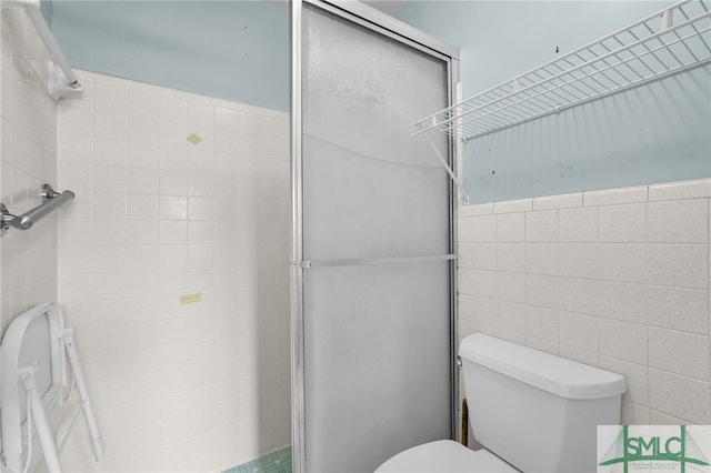 bathroom featuring toilet and tile walls