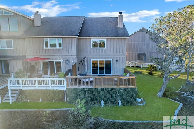 back of property featuring a yard and a deck