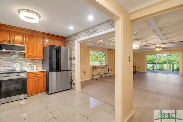 kitchen with a healthy amount of sunlight, ceiling fan, stainless steel appliances, and light tile patterned floors