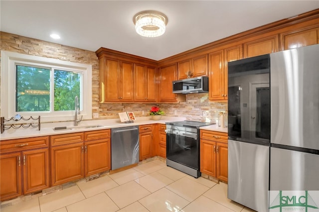 kitchen with decorative backsplash, appliances with stainless steel finishes, light tile patterned floors, and sink