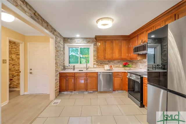 kitchen featuring light tile patterned floors, stainless steel appliances, tasteful backsplash, and sink