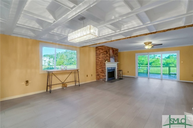 unfurnished living room featuring beam ceiling, plenty of natural light, coffered ceiling, and hardwood / wood-style flooring