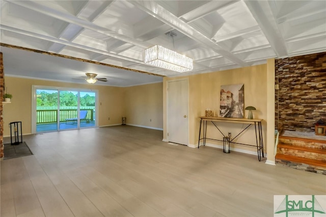 unfurnished living room with coffered ceiling, beamed ceiling, hardwood / wood-style flooring, ceiling fan with notable chandelier, and ornamental molding