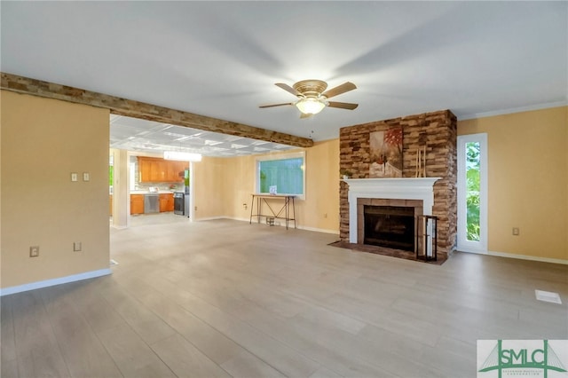 unfurnished living room featuring beamed ceiling, light hardwood / wood-style floors, ceiling fan, and a tiled fireplace