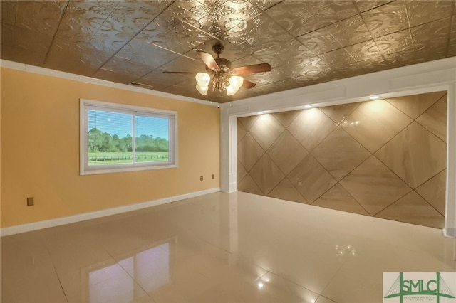 spare room with tile patterned floors, ceiling fan, and ornamental molding