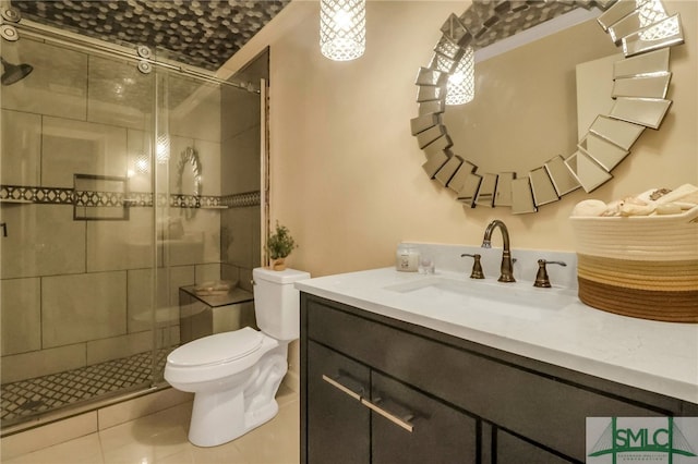 bathroom with tile patterned flooring, vanity, a shower with door, and toilet