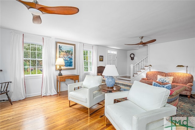 living room featuring ceiling fan and light hardwood / wood-style floors