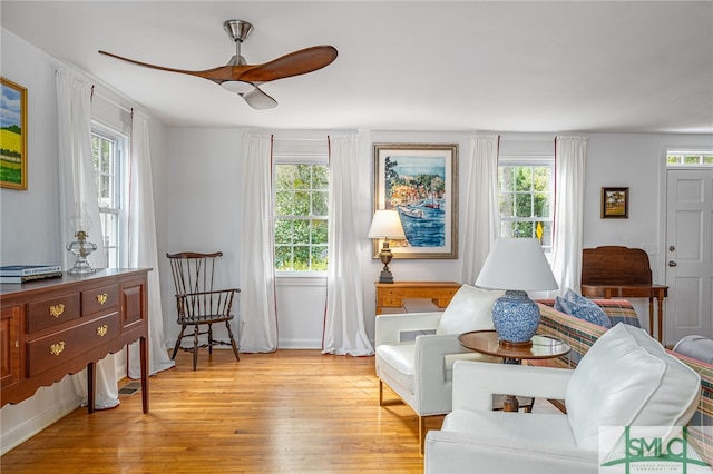 living area featuring ceiling fan, light hardwood / wood-style floors, and a wealth of natural light