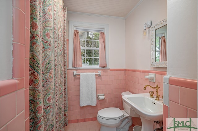 bathroom with walk in shower, crown molding, sink, tile walls, and tile patterned flooring