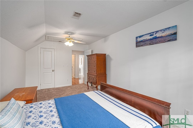 bedroom with a textured ceiling, carpet floors, vaulted ceiling, and ceiling fan